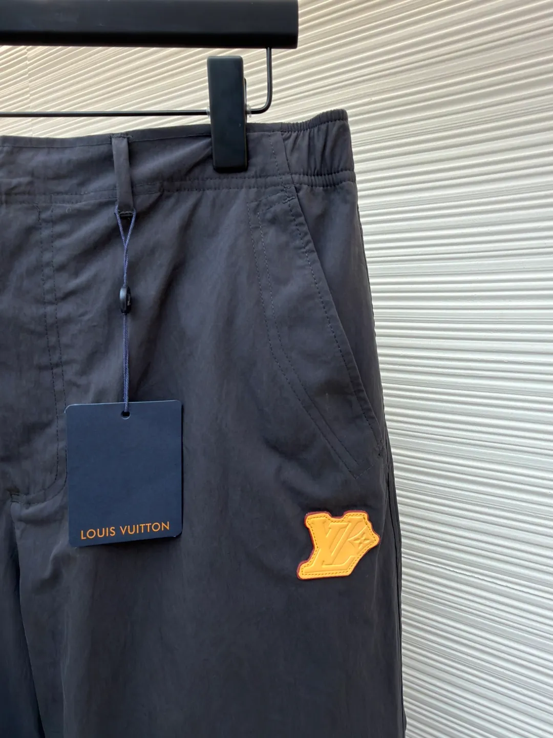 LOUIS VUITTON Small flower embossed label casual trousers ●Original version: purchased and developed for 9999 ●Item number: 1682065-B40 ●Fabric: technical cotton blended fabric ●Technology: embossed label production ●Color: gray ●Version: fitted version ●Weight: about 460 grams ●Size: 44-46-48-50 ●Description: Made of a blended fabric of 68% cotton and 32% nylon, the material ratio accurately balances the advantages of the two fibers: cotton provides a natural skin-friendly feel, breathability and daily wearing comfort; while up to 32% nylon significantly enhances the fabric's wear resistance, tear resistance and overall durability, and may be treated to impart certain water-repellent properties. It shows that the fabric has undergone advanced finishing processes such as mercerization to make the fiber surface smoother, resulting in a smoother feel than ordinary cotton. Italian pockets and trompe l'oeil topstitched flaps: Italian pockets usually refer to inner patch pockets with extremely clean lines and no pleats. The trompe l'oeil effect topstitching uses sewing thread that contrasts with the color of the fabric to create a visual effect that looks like a three-dimensional flap through precise stitches. Its function is to add delicate decorative lines and visual interest while maintaining the flat function of the pocket. Pressed logo leather patch on the left leg: High-quality leather is laser-cut into a specific shape and then heat-pressed or sewn onto the trouser legs. The effect of this process step is to instantly enhance the luxurious quality of the piece and create a sharp material contrast with the cotton main body. On the leather patch, the brand's classic floral logo is embossed with a high-temperature mold. The pattern created this way is discreet, permanent and smooth to the touch, complementing the luxurious texture of the leather as a finishing touch. The overall wiring is straight and delicate, the fabric is comfortable and soft, and the color is consistent without color difference. It can be matched with the same style to create a fashionable look and control various occasions. Customized accessories, complete with three standards, same style for men and women!